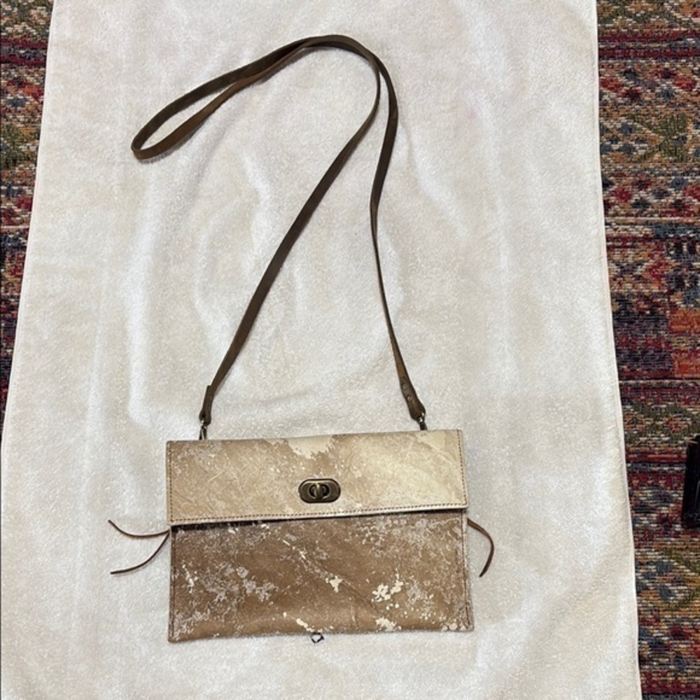 Tan crossbody with Flap Closure western style.